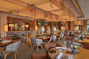 ein Restaurant mit Holztischen und -stühlen in der Unterkunft Louis Hotel in München