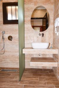 a bathroom with a sink and a mirror at EXOHI STUDIOS in Sarti