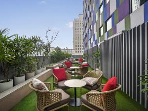 a balcony with chairs and tables on a building at ibis Kolkata Rajarhat - An Accor Brand in Kolkata