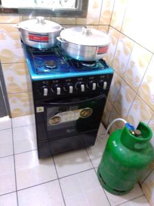 a stove with two pots on top of it in a kitchen at La casa in Kribi