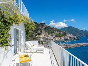 a balcony with chairs and a view of the water at Hotel Miramalfi in Amalfi
