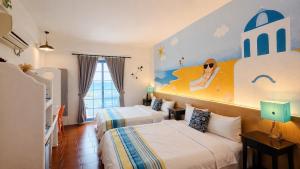 a hotel room with two beds and a mural on the wall at 海灘戀情 Beach Love 近沙灘-國旅卡特約商店 陽台房 希臘地中海風格 in Eluan +82 photos