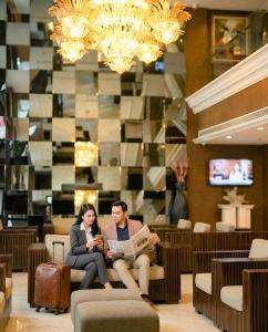 a man and a woman sitting in a lobby at Imperial Heritage Hotel Melaka I City Centre I Free Wifi I Free Parking l Free Club Lounge Access in Malacca