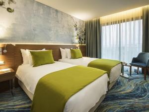 a hotel room with two beds with green sheets at ibis Styles Izmir Bornova in İzmir +35 photos