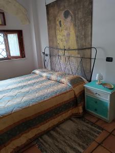 a bedroom with a bed and a painting on the wall at Il Posto delle Rose 1 in San Polo dei Cavalieri
