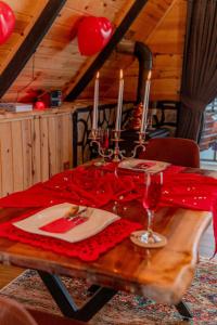 a wooden table with wine glasses and a red table cloth at Himora Suit Bungalov in Ardeşen