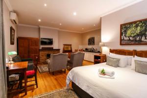 a bedroom with a bed and a living room at Murray Street 137 Guesthouse in Pretoria
