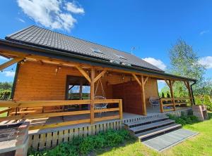 a log cabin with a porch and a deck at Apartamenty Ewelka in Okuninka