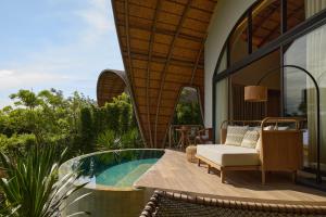 a villa with a swimming pool and a patio at dusitD2 Khao Yai in Mu Si