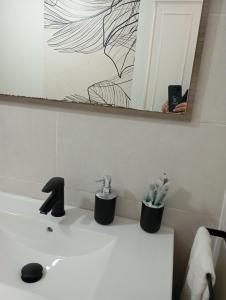 a bathroom sink with a faucet and a mirror at Apartamento Ons in Bueu