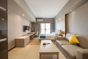 a hotel room with a couch and a bed at Foshan Poltton International Serviced Apartment in Foshan