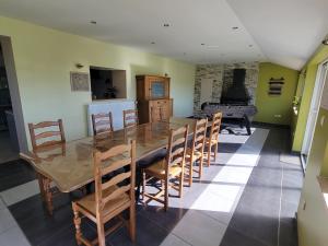 a dining room with a table and chairs and a piano at Les Gîtes de la chapelle blanche in Anor