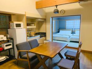 a kitchen with a table and a bedroom with a bed at ネイチャーゲート軽井沢 in Kita-karuizawa