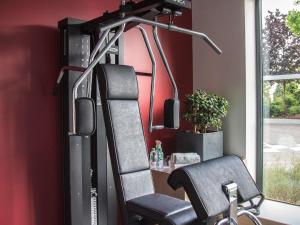 a gym with a chair in front of a window at ibis Styles Bâle-Mulhouse Aéroport in Blotzheim