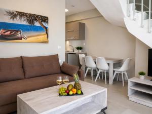 a living room with a couch and a table with fruit at Casale Luxury House - Luxury Garden Maisonettes in Nikiti