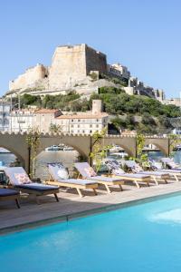 a row of chaise lounge chairs next to a swimming pool at Solemare in Bonifacio