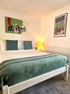 a bedroom with a large bed with a green blanket at Upper Rock Brighton – Guest House in Brighton & Hove