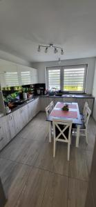a kitchen with a table and chairs in a room at Ojcowski Las in Biały Kościół