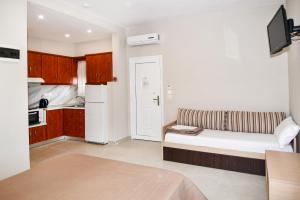 a living room with a couch and a kitchen at EXOHI STUDIOS in Sarti