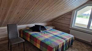 a bedroom with a bed and a chair and a window at Taga-Kalda in Nüpli