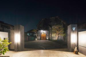 an entrance to a house at night with lights at SOSHIJI Arashiyama in Kyoto +74 photos