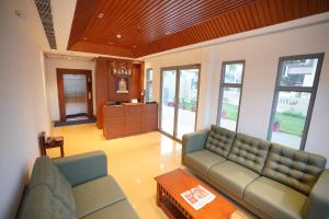 a living room with a couch and a table at Hotel Grand Vekasa in Salem