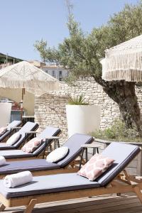 a row of lounge chairs with umbrellas on a patio at Solemare in Bonifacio