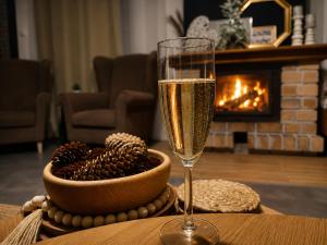 a glass of champagne sitting on a table with a bowl of christmas cookies at Vila Zornička in Ždiar