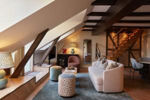a living room with stairs and a couch and chairs at Ascot Hotel in Copenhagen
