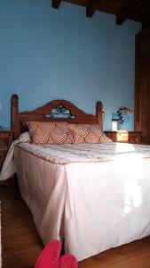 a bedroom with a large bed with white sheets and red shoes at Casa Adela El Tuxu in Perlleces