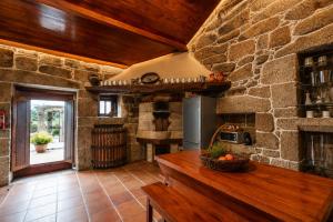 a kitchen with a stone wall and a counter top at Quinta da Eira do Sol in Guimarães