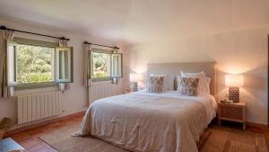 a bedroom with a white bed with two windows at Es Mayolet in Manacor +75 photos
