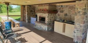 a living room with a stone fireplace on a deck at Põhjakalda in Nüpli