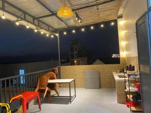 a patio with a table and chairs on a balcony at Gạo homestay Dốc lết in My Luong