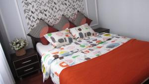 ワルシャワにあるCity Charm Warszawaのベッドルーム1室(オレンジ色の毛布と枕付きのベッド1台付)