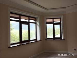 two windows in an empty room with at Village House in Zhabagly
