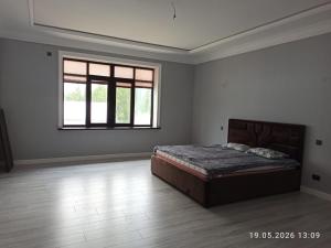a white room with a bed and a window at Village House in Zhabagly