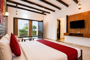 ein Schlafzimmer mit einem großen Bett und einem Flachbildfernseher in der Unterkunft Baris river resort Corbett in Rāmnagar + 48 Fotos