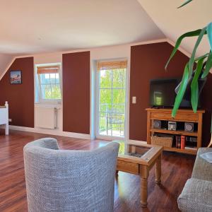 a living room with a table and a tv at Apartmenthaus Ostseeluft in Lohme