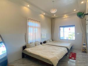 two beds in a room with a window at Gạo homestay Dốc lết in My Luong +7 photos