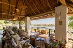 a living room with furniture and a view of the water at Buhala Lodge in Malelane