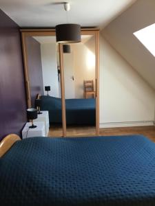 a bedroom with a blue bed and a mirror at Maison 1er étage chéreng 6kms stade Pierre Mauroy 4 personnes in Chéreng