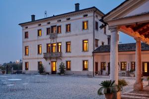 a large building with lights on in a courtyard at Villa Stecchini in Bassano del Grappa