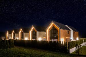 a house at night with lights on it at Olivina Park Spa - domki z dostępem do krytego basenu, saun, wyżywienia i atrakcji dla dzieci in Niechorze