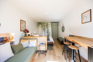 a living room with a couch and a table at Studio Bord-Eau, terrasse et jardin in Saint-André-de-Cubzac