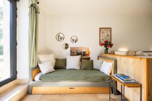 a small couch in a room with a window at Studio Bord-Eau, terrasse et jardin in Saint-André-de-Cubzac