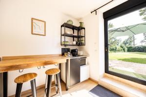 a kitchen with a counter and stools next to a window at Studio Bord-Eau, terrasse et jardin in Saint-André-de-Cubzac +14 photos