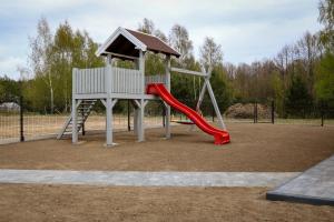 a playground with a red slide and a play structure at Przystanek Semlin - Za Jeziorem in Semlin