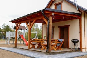 a pavilion with a picnic table and a playground at Przystanek Semlin - Za Jeziorem in Semlin