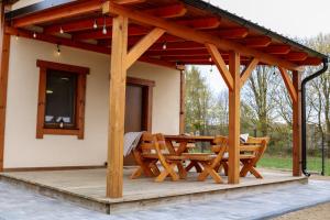 a pavilion with a table and chairs on a patio at Przystanek Semlin - Za Jeziorem in Semlin